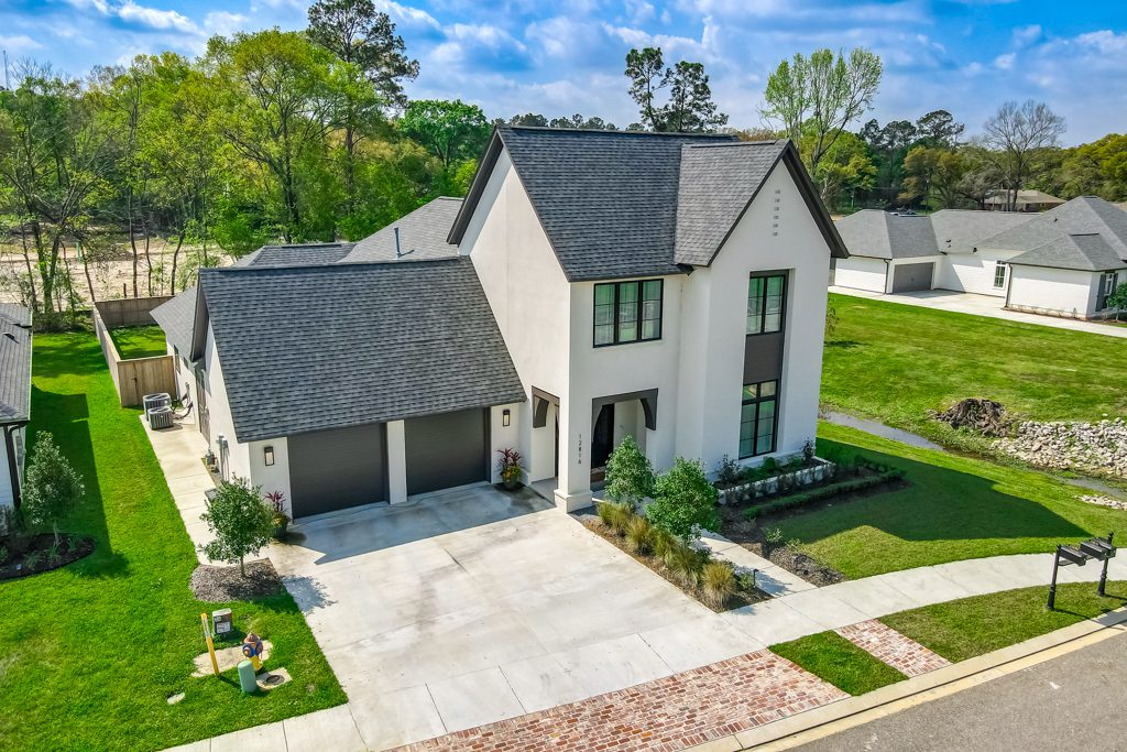 Modern two-story house with a double garage and neatly landscaped front yard.