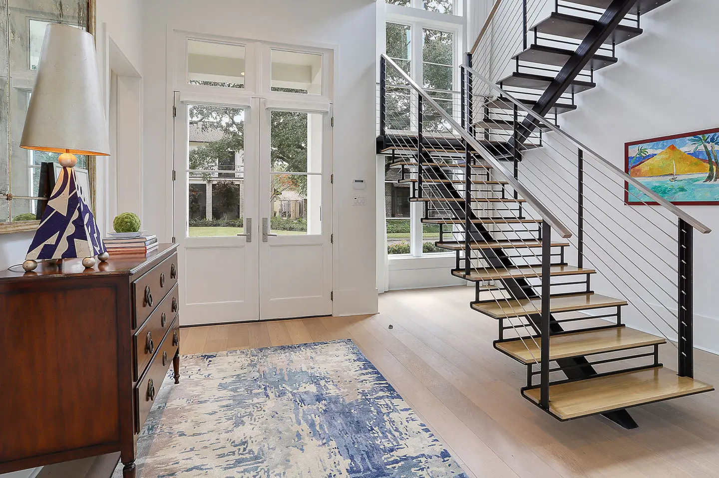Modern staircase with glass railing in a bright room.